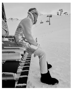 a person sitting on a bench in the snow