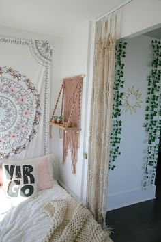 a bedroom with white walls and hanging plants on the wall