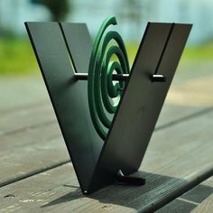 a close up of a metal object on a wooden table with grass in the background