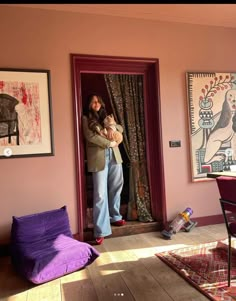 a woman standing in front of a doorway holding a cat