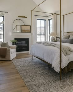 a bedroom with a bed, chair and fireplace in the corner is furnished with neutral colors