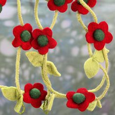 red and green flowers are hanging from a tree