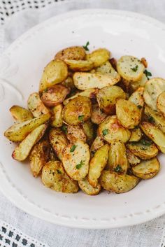 a white bowl filled with fried potatoes on top of a table