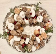 a christmas wreath made out of doughnuts and cranberries on a platter