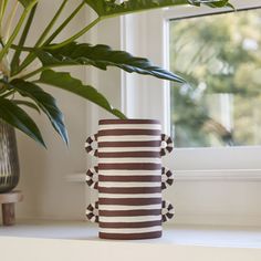 a potted plant sitting on top of a window sill next to a vase