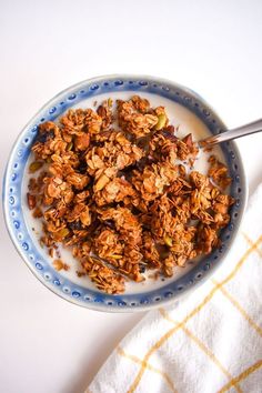 a bowl filled with granola on top of a blue and white plate next to a towel