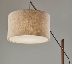 a lamp that is on top of a wooden pole with a light fixture underneath it