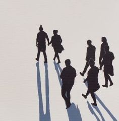 a group of people walking down a snow covered slope in the wintertime with long shadows on the ground