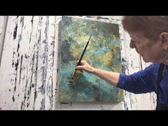 an older woman is painting on the easel