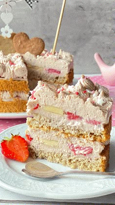 two pieces of cake on plates with strawberries