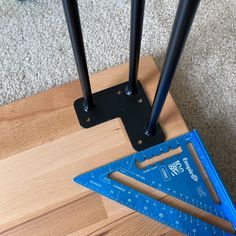 a pair of blue rulers sitting on top of a wooden floor