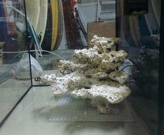 a bunch of rocks sitting on top of a glass table in front of surfboards