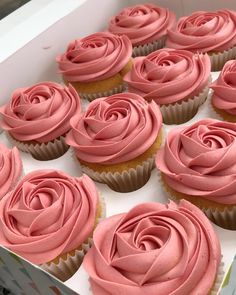 cupcakes with pink frosting in a box