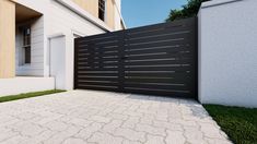 a black and white fence in front of a house with grass on the ground next to it