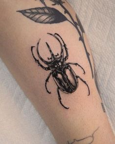 a black and white photo of a beetle on the left arm with a flower in it's center