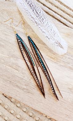 Brown grizzly, grizzly, and teal grizzly feathers on paperclip gold chain 7 inches long. Lead/nickel free hooks with rubber backs. Return to shop 👇 https://www.etsy.com/shop/AxeandSparrow PLEASE MAKE SURE YOUR ADDRESS IS ENTERED CORRECTLY. IF YOU ARE DOING A GUEST CHECKOUT PLEASE PLEASE DOUBLE CHECK YOUR ADDRESS AND YOUR EMAIL. THANK YOU! *All feathers are cruelty free.  All hooks are lead and nickel free. All leather is genuine leather. *Please feel free to contact me with ANY questions or custom creations. *Please understand that each feather is unique and natural so with that comes variances, please allow for lighting variances also. *The time it takes me to get you your earrings depends on current order volume, if you need them by a specific date please feel free to message me and I'l Boho Feathers, Earrings Bohemian, Boho Gifts, Western Jewelry, Black Feathers, Bohemian Earrings, Trombone, Earrings Long, Feather Earrings