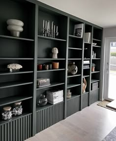 a room filled with lots of green bookshelves