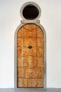 a wooden door with a circular window in the center and an arch at the top