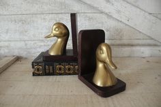 two golden ducks sitting on top of books