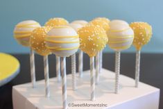 there are many yellow and white cake pops on the table