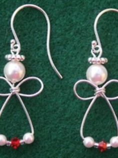 pair of earrings with bow and pearls on green carpeted surface, close up view