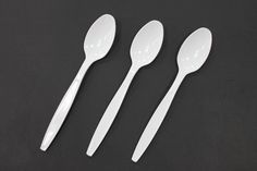 three spoons and two forks on a black surface