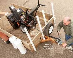 a man is working on a small trailer with an air compressor attached to the back