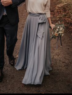 a man and woman walking down a dirt road