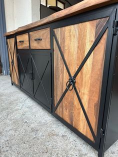 a large wooden cabinet sitting on top of a cement floor next to a wall and door