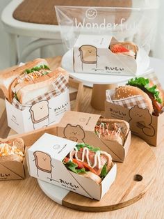 several sandwiches in boxes sitting on a table