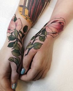 two hands with tattoos and flowers on them