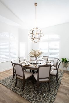 a dining room table with chairs and a chandelier