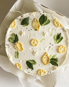 a white cake with lemons and leaves on it