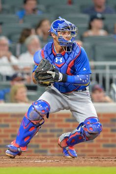 a baseball player holding a catchers mitt on top of a field in front of a crowd