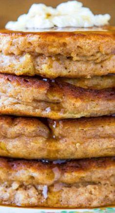 stack of pancakes with butter and syrup sitting on top of a plate next to mashed potatoes