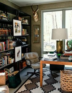 a living room filled with lots of furniture and bookshelves next to a window