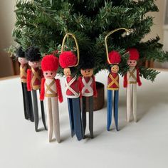 wooden toy soldiers are lined up in front of a christmas tree