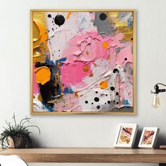 an abstract painting hangs on the wall above a table