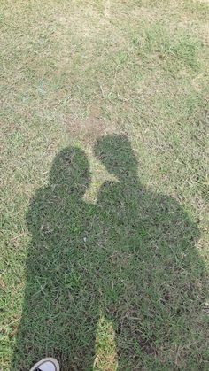 the shadow of a person standing in grass