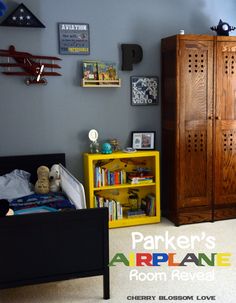 a child's bedroom is decorated in blue and yellow, with an airplane on the wall