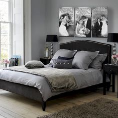 a bedroom with grey walls and pictures on the wall above the bed, along with two nightstands