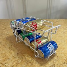 three cans of soda in a metal holder