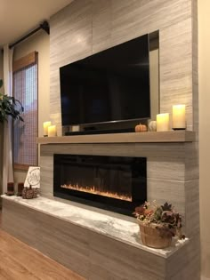 a living room with a fireplace and television on the wall in front of it's flat screen tv