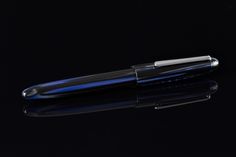 a black and blue pen on a reflective surface