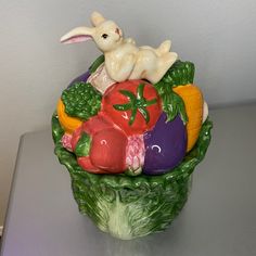 a ceramic figurine of a rabbit sitting on top of vegetables