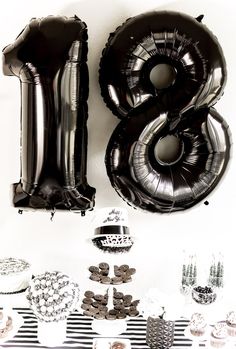 the number eight balloon is next to some other balloons and cupcakes on a table