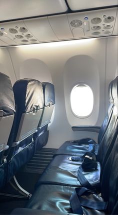 the inside of an airplane with two seats and one seat folded up in black leather