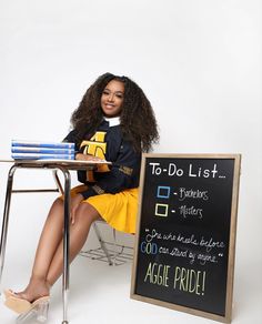 a woman sitting at a table with a blackboard in front of her that says to do list