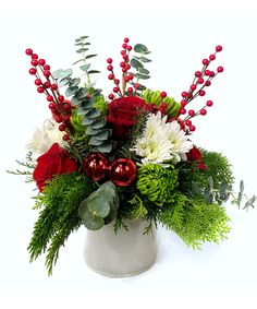 a white vase filled with flowers and greenery