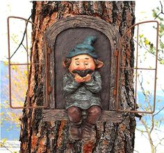 a statue of a gnome sitting on top of a tree